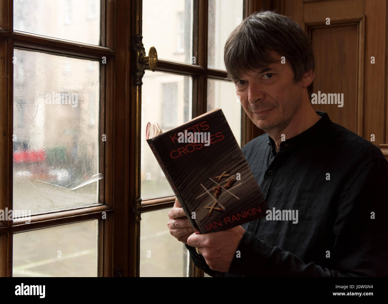 Thursday 29th of June 2017: Ian Rankin at the Writers Museum with a copy of his first book, Knots and Crosses. Joining the ranks of Sir Walter Scott, Robert Burns and Robert Louis Stevenson; author Ian Rankin will be celebrated in a new exhibition at Edinburgh’s Writers’ Museum.  A rare selection of personal items, manuscripts and images belonging to the best-selling writer will be displayed in a new exhibition celebrating the 30th anniversary of his much-loved super sleuth, Detective Inspector Rebus.  Co-curated between the author and the Museum, Rebus30 explores the relationship between Rank Stock Photo