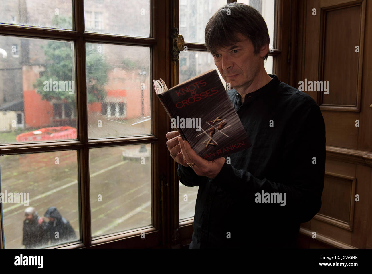 Thursday 29th of June 2017: Ian Rankin at the Writers Museum with a copy of his first book, Knots and Crosses. Joining the ranks of Sir Walter Scott, Robert Burns and Robert Louis Stevenson; author Ian Rankin will be celebrated in a new exhibition at Edinburgh's Writers Museum. A rare selection of personal items, manuscripts and images belonging to the best-selling writer will be displayed in a new exhibition celebrating the 30th anniversary of his much-loved super sleuth, Detective Inspector Rebus. Stock Photo