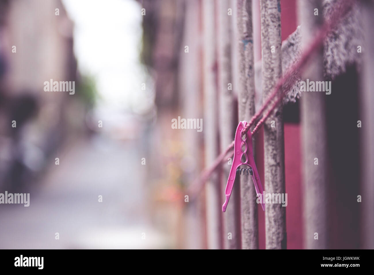 Vintage view of Clothes peg pinned to a bench with dark wall in a