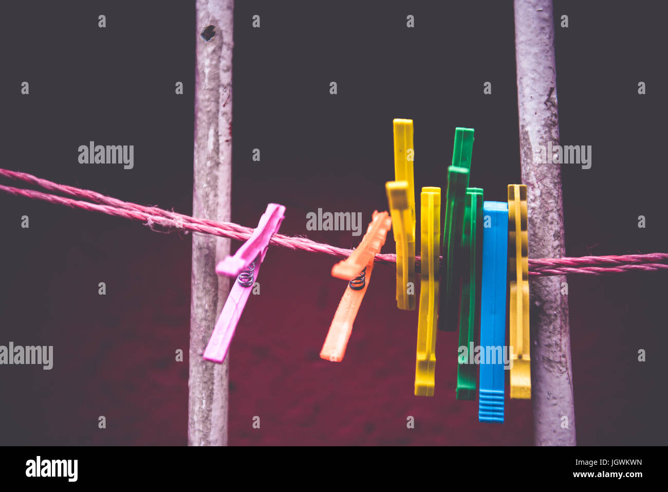 Vintage view of Clothes peg pinned to a bench with dark wall in a