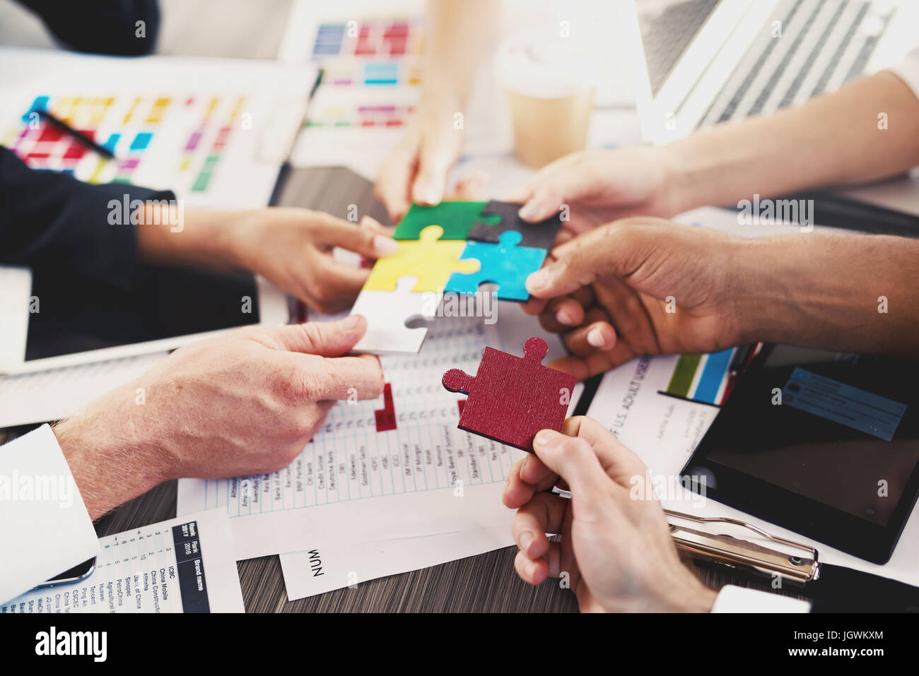 Team of businessmen work together to build a puzzle. Concept of unity and partnership Stock Photo