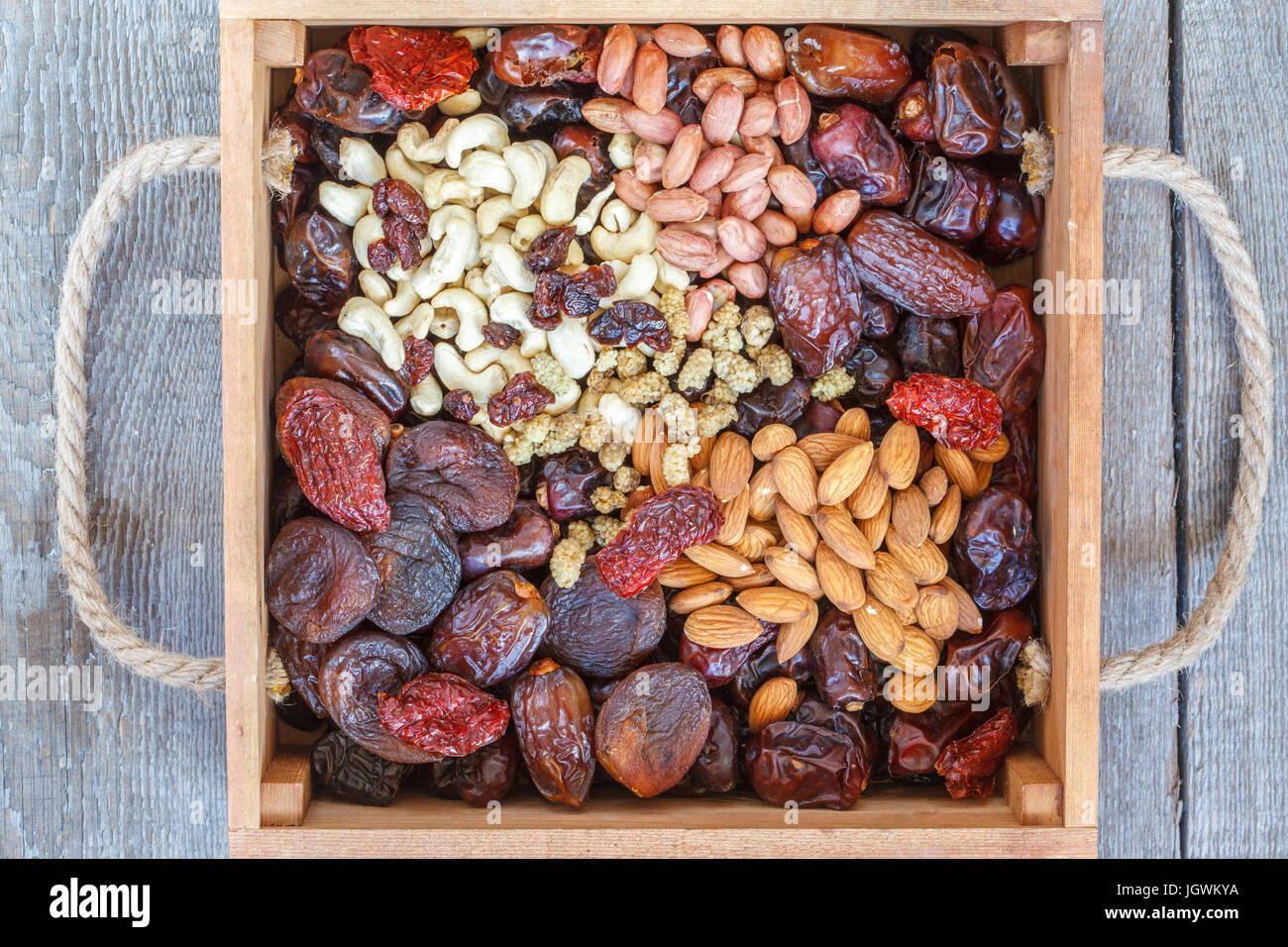 Different types of nuts and dried fruits in a wooden box. Healthy