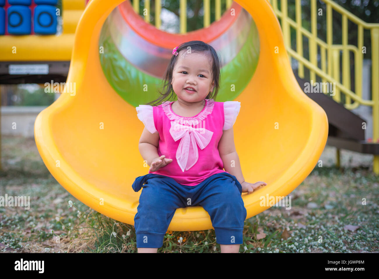 Toddler girl playing on a slide at children playground Stock Photo - Alamy