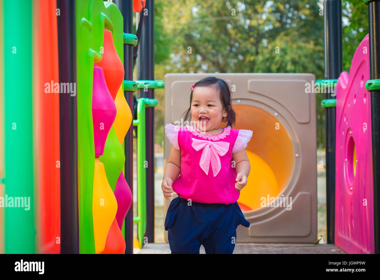 Toddler girl playing on a slide at children playground Stock Photo - Alamy