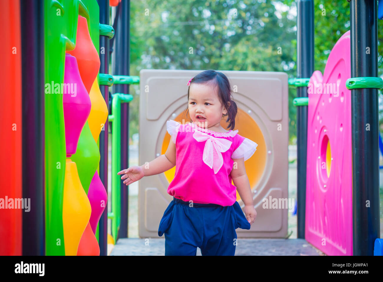 Toddler girl playing on a slide at children playground Stock Photo - Alamy