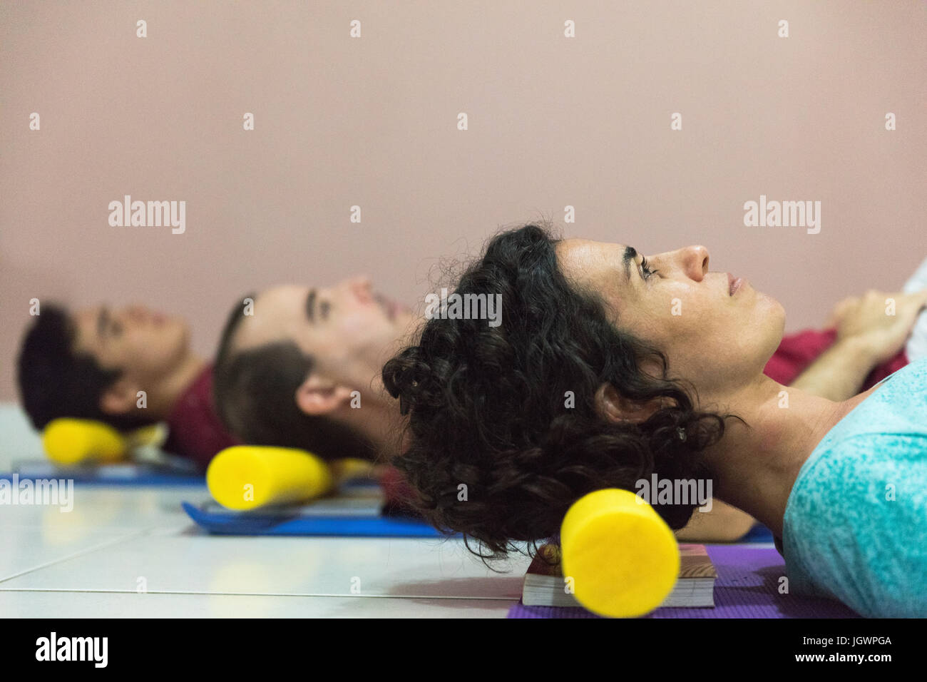 People at yoga class resting head on block Stock Photo