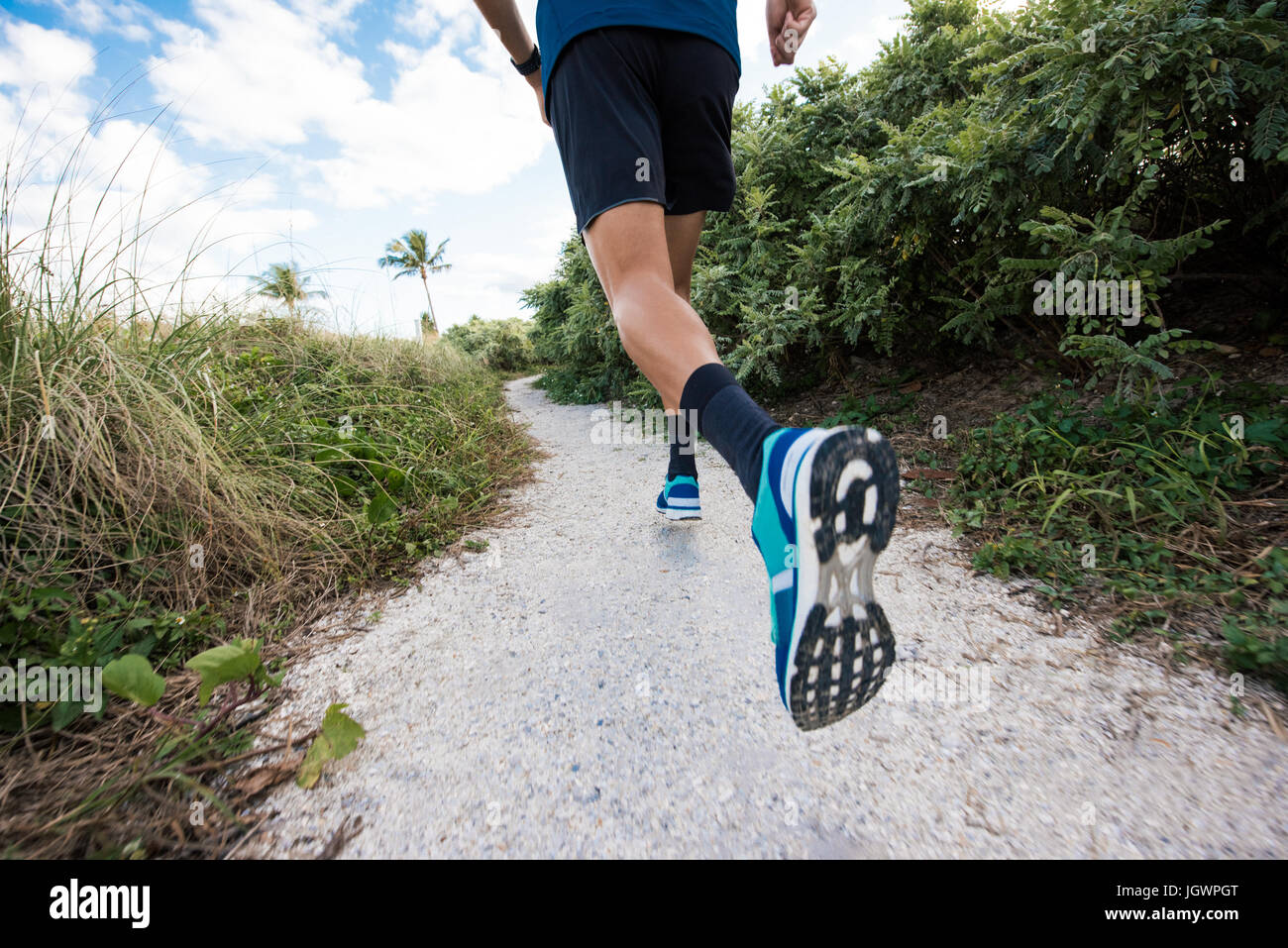 Young man exercising, running outdoors, rear view, low section, South Point Park, Miami Beach, Florida, USA Stock Photo