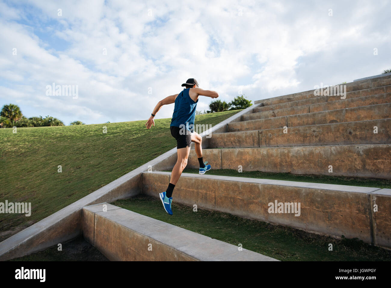 Young man exercising, running outdoors, leaping up steps, South Point Park, Miami Beach, Florida, USA Stock Photo