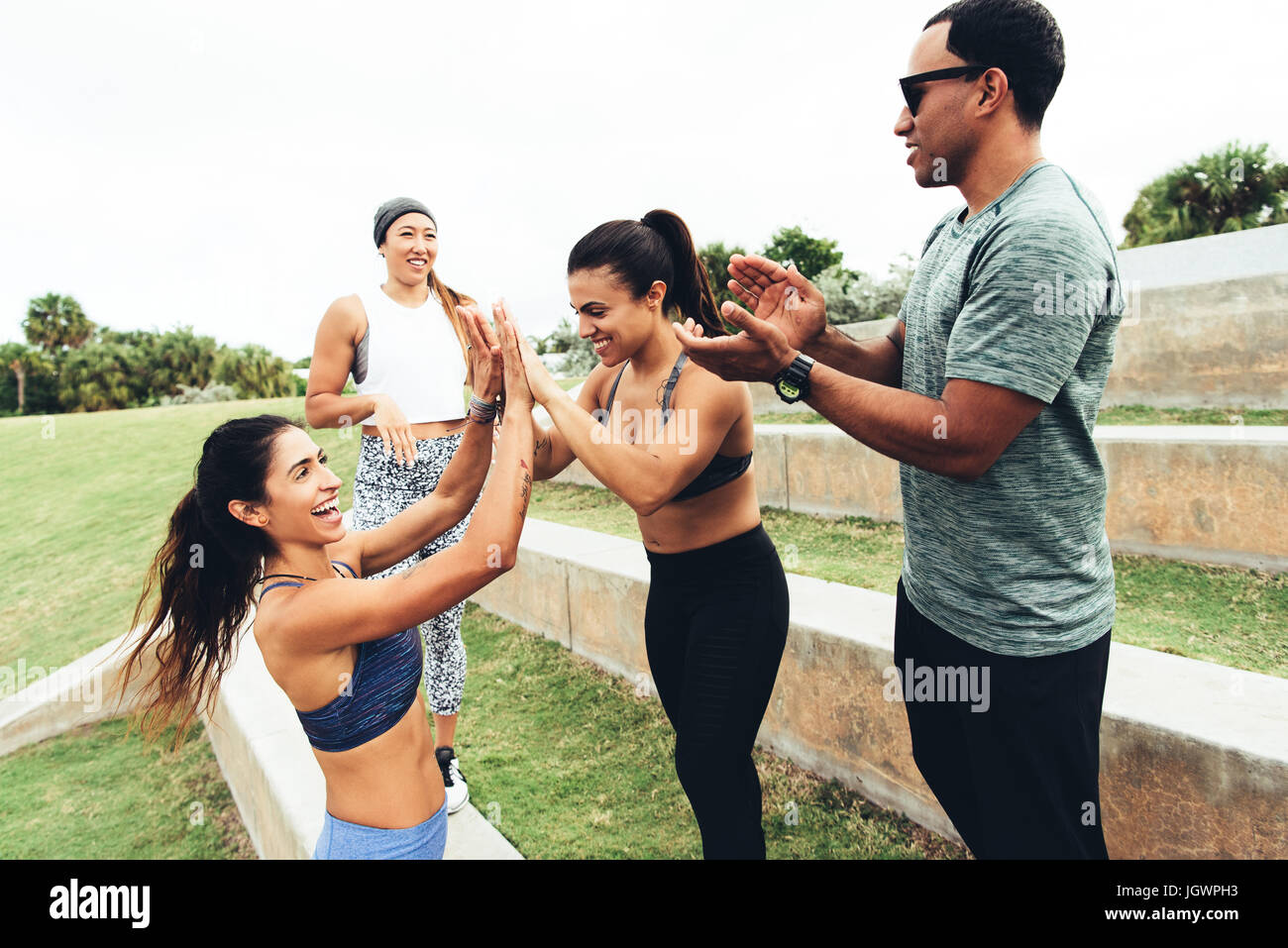 Three women celebrating workout, personal trainer clapping, Point Park, Miami Beach, Florida, USA Stock Photo
