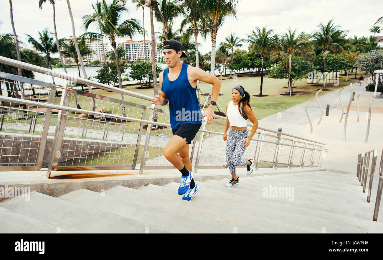 Man and woman exercising outdoors, running up steps, elevated view, South Point Park, Miami Beach, Florida, USA Stock Photo