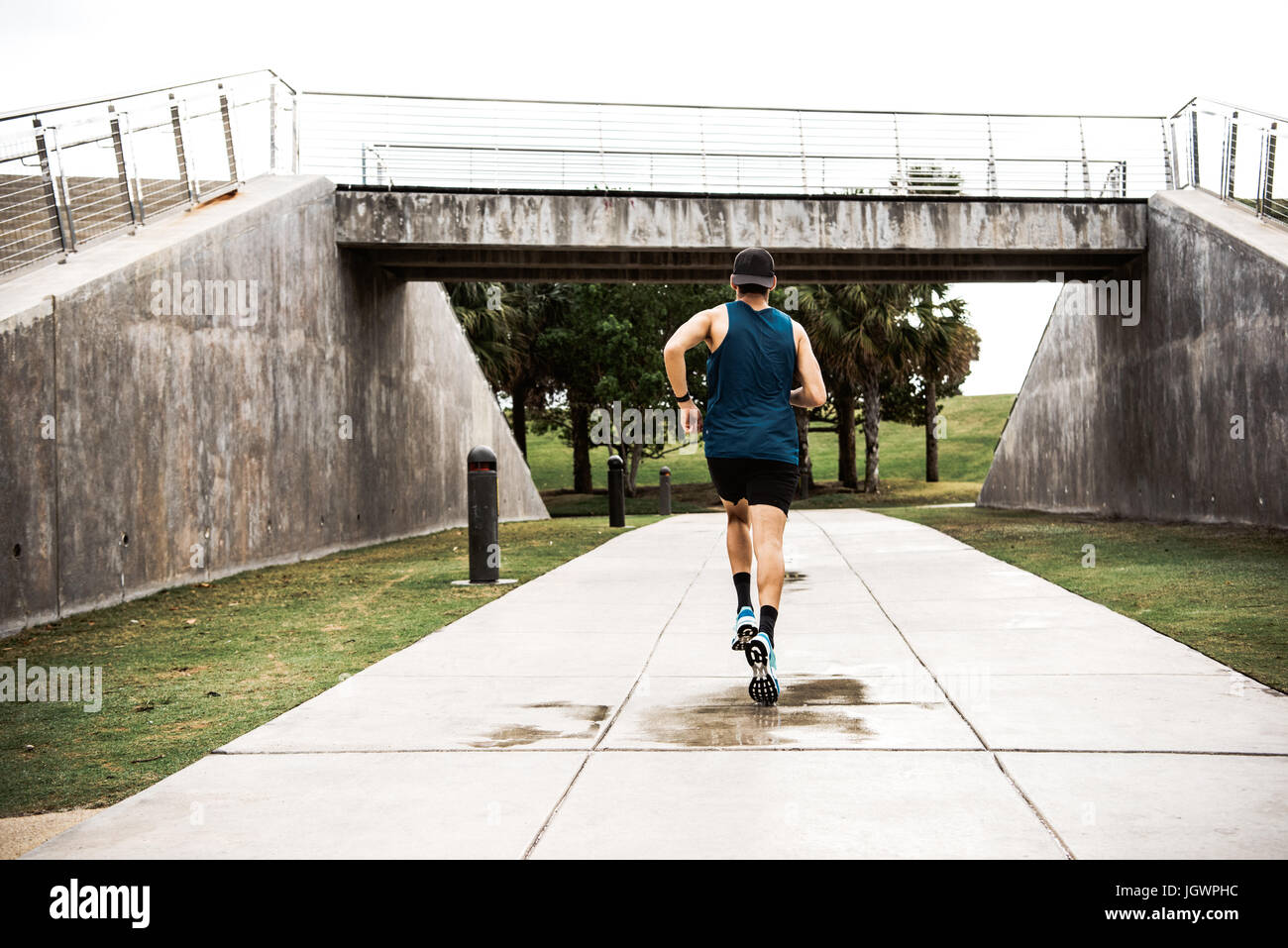 Young man exercising outdoors, running, rear view, South Point Park, Miami Beach, Florida, USA Stock Photo