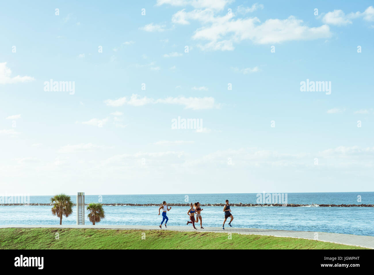 Three women working out, running, with personal trainer, Point Park, Miami Beach, Florida, USA Stock Photo