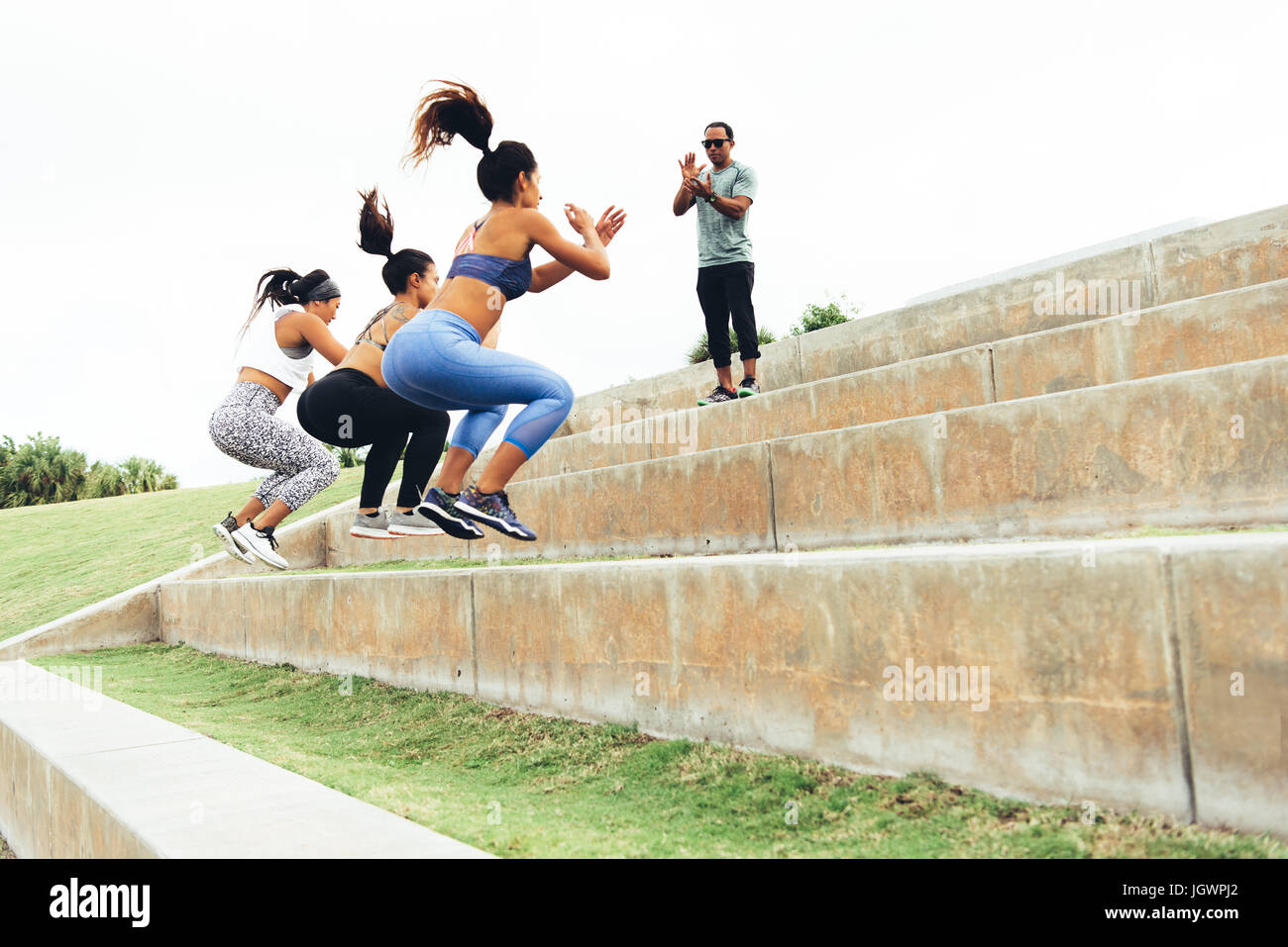 Three women working out with personal trainer, South Point Park, Miami Beach, Florida, USA Stock Photo