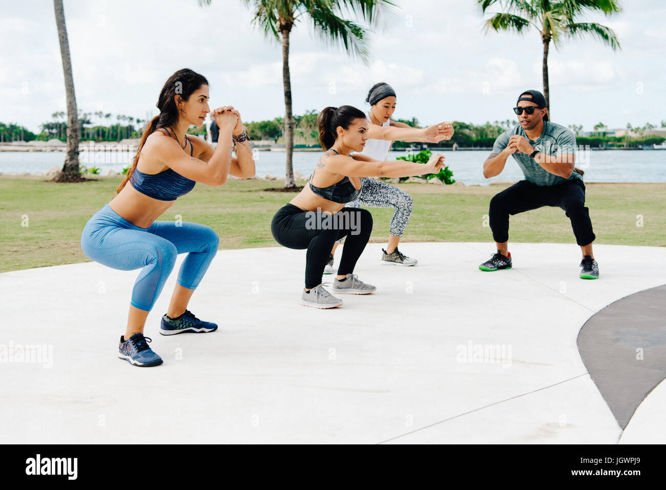 Three women working out with personal trainer, South Point Park, Miami Beach, Florida, USA Stock Photo