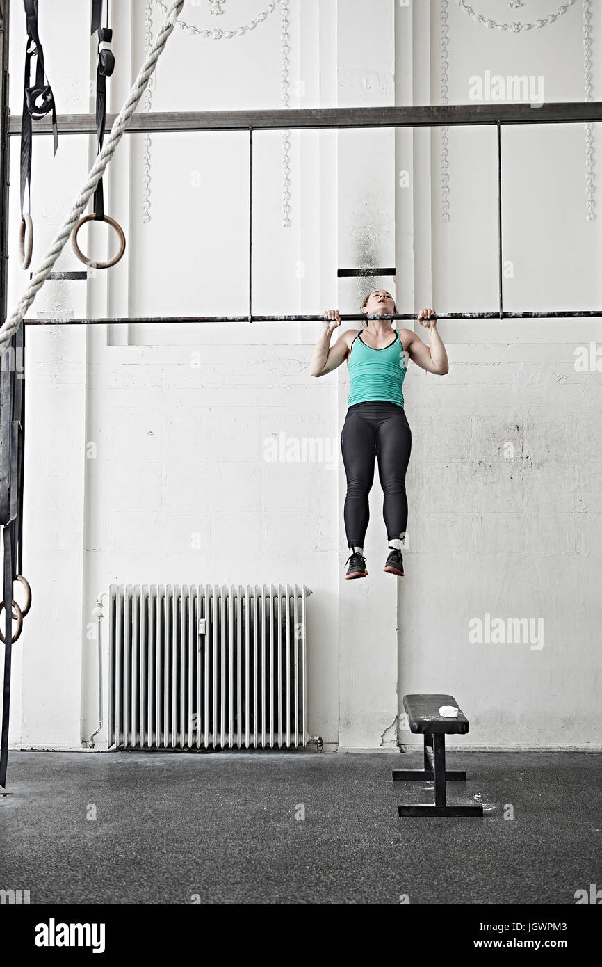 Woman doing chin-up in cross training gym Stock Photo