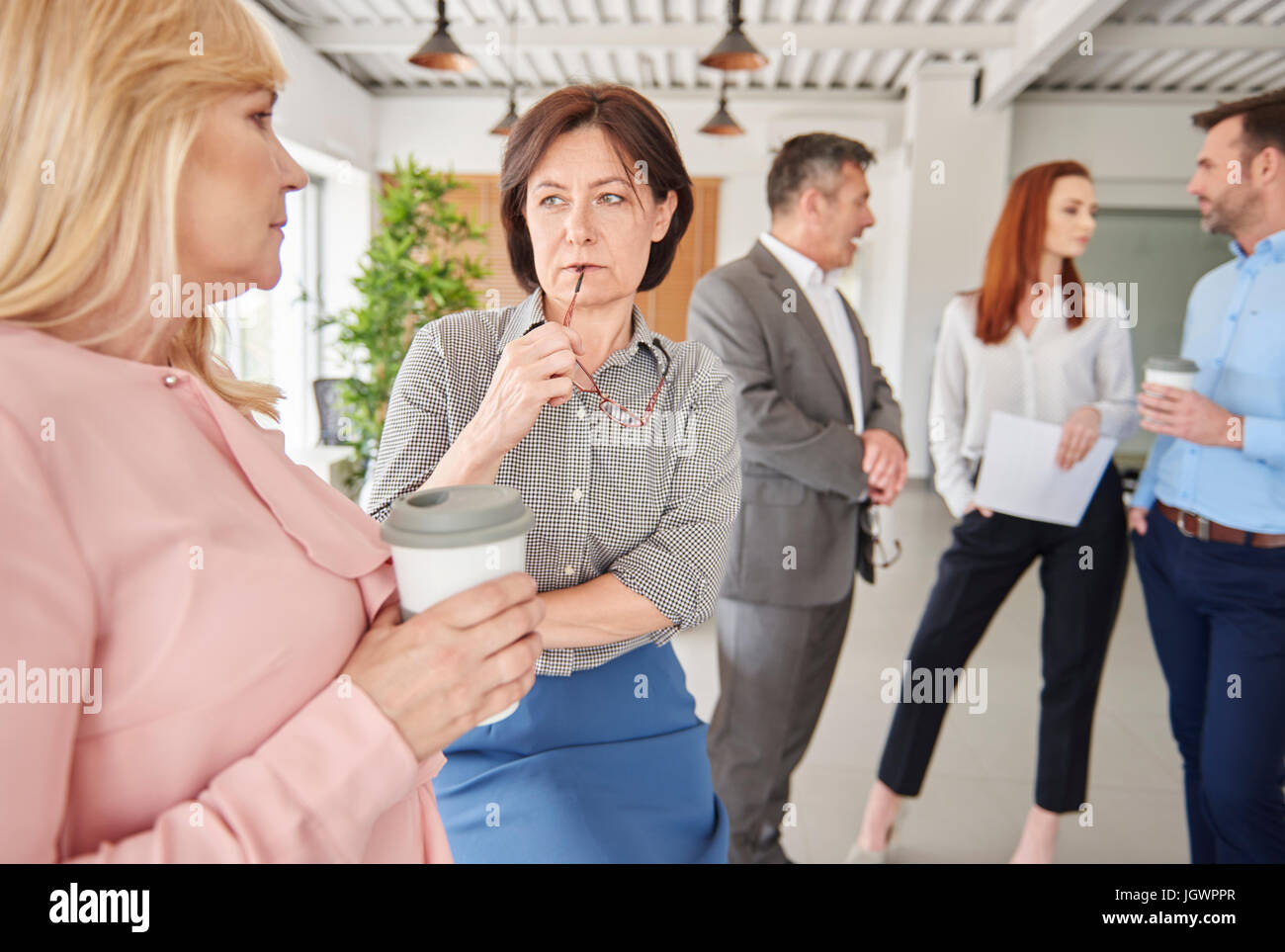 Colleagues standing in office talking Stock Photo