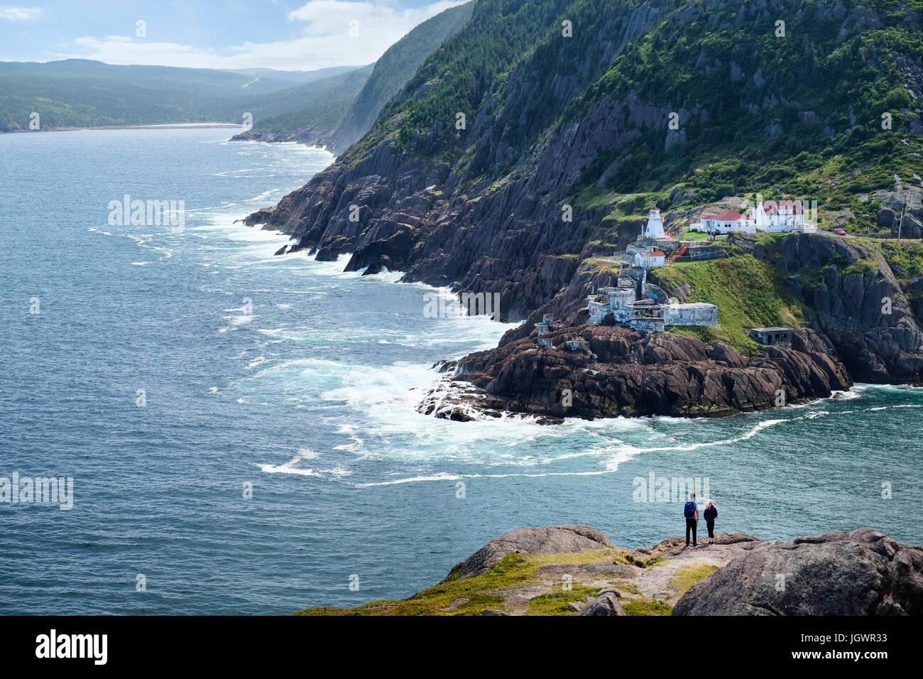 Couple looking out from coastal cliff, St John's, Newfoundland, Canada Stock Photo