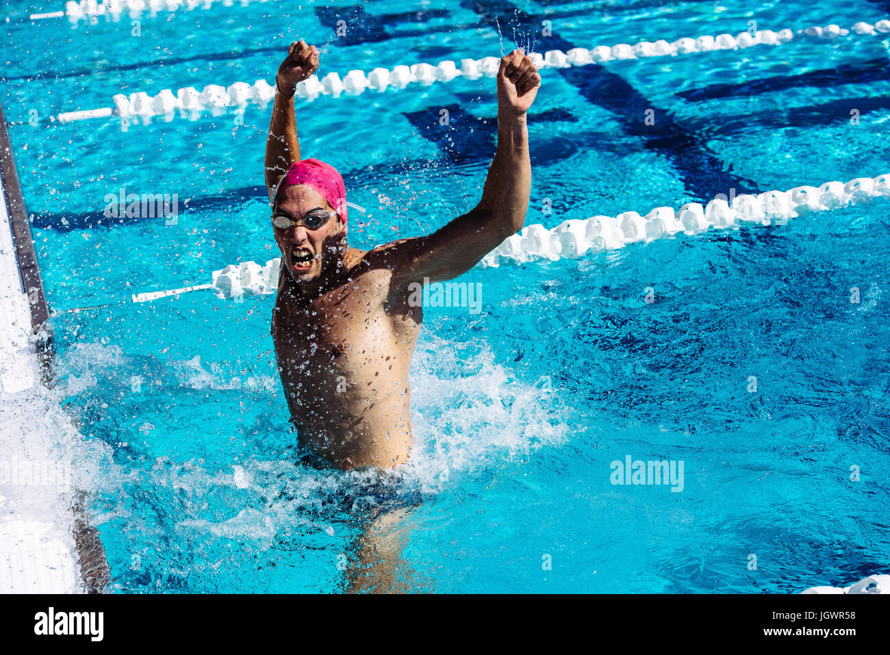 Swimmer in water in pool gesturing triumph Stock Photo