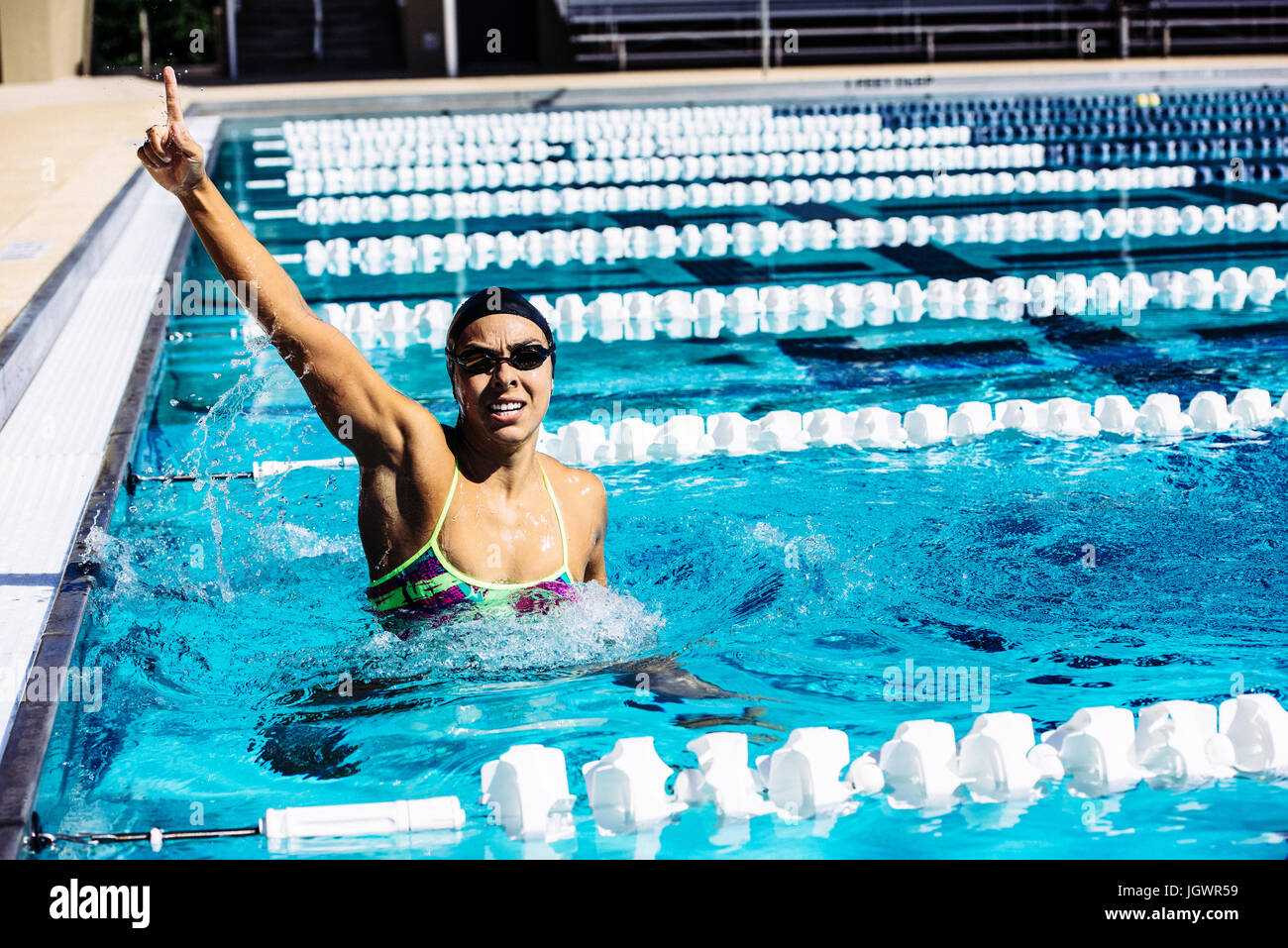 Swimmer in water in pool gesturing triumph Stock Photo