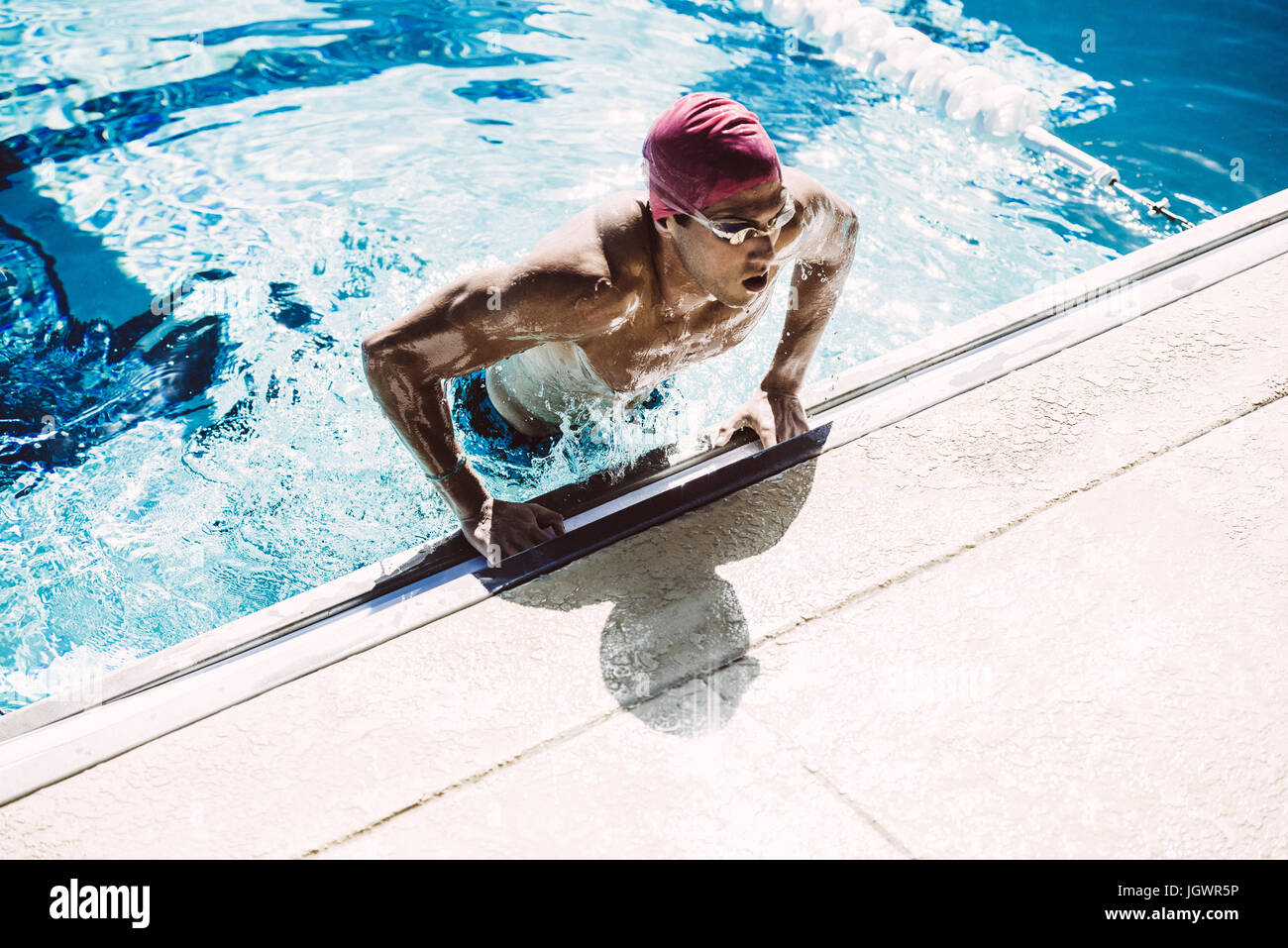 Swimmer climbing out of pool Stock Photo Alamy