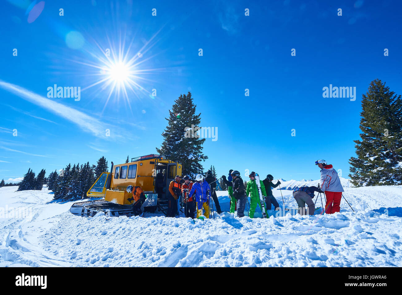 Male and female skiers on ski slope by snow coach, Aspen, Colorado, USA Stock Photo