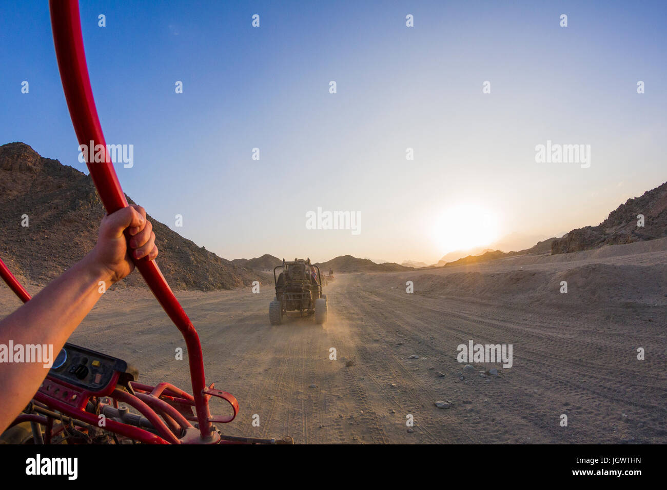 Personal perspective view of man's arm driving beach buggy in desert, Hurghada, Al Bahr al Ahmar, Egypt Stock Photo
