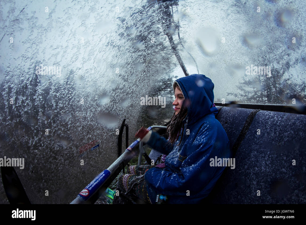 Young female hiker in chairlift during mountain snowstorm Stock Photo