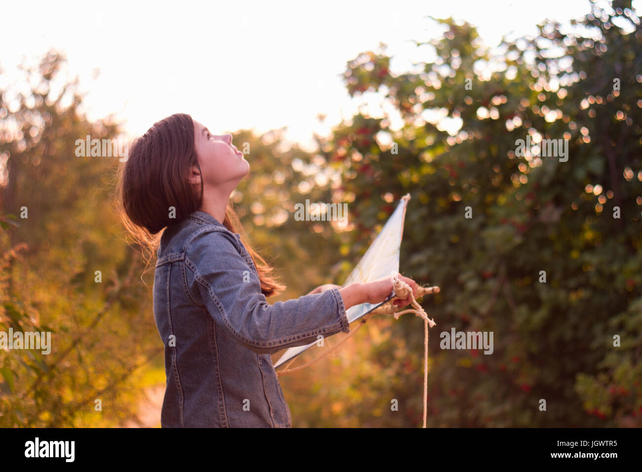 Teenage girl holding kite looking up at sky Stock Photo