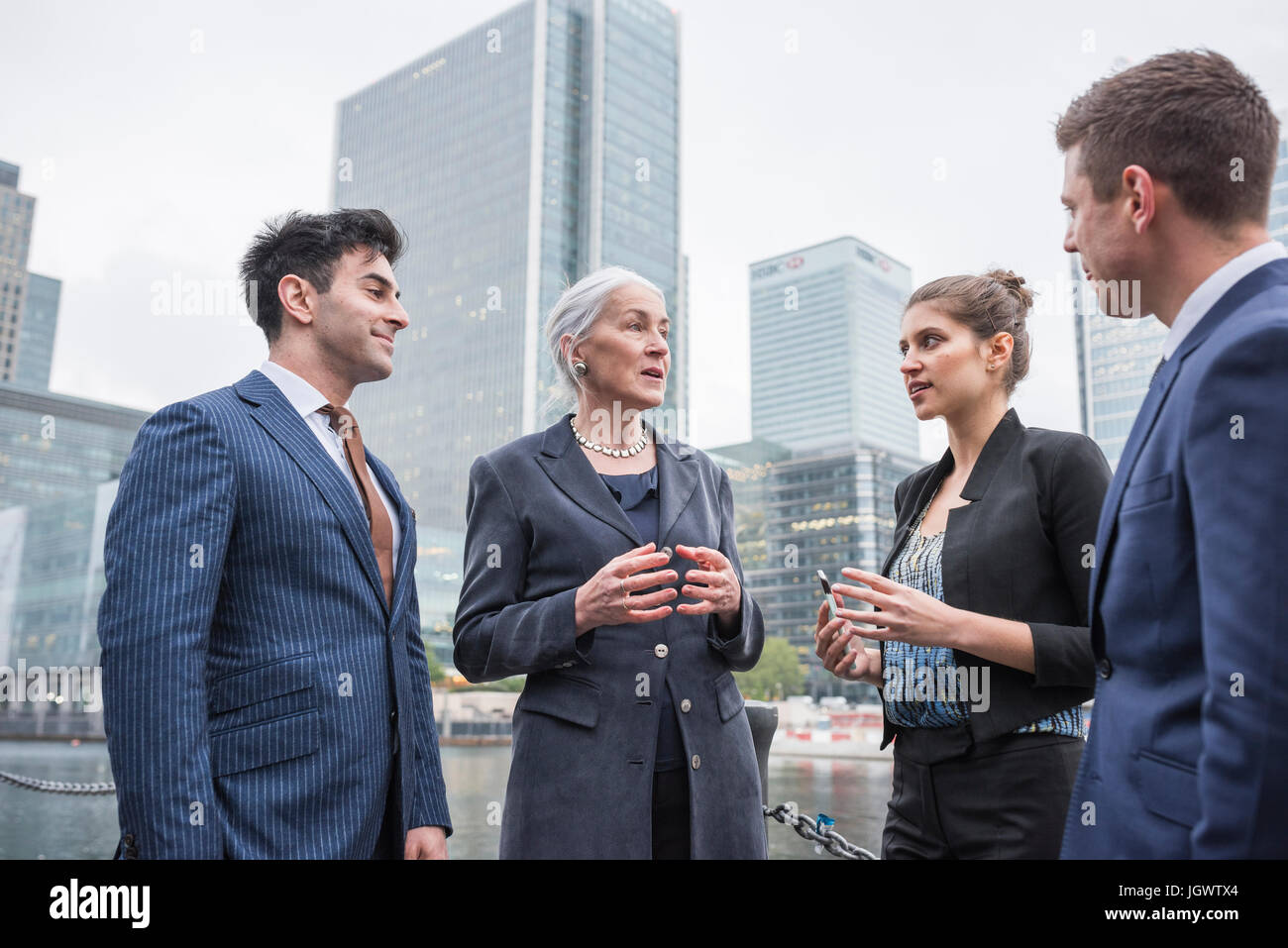 Businessman and businesswoman in discussion outdoors, Canary Wharf, London, UK Stock Photo