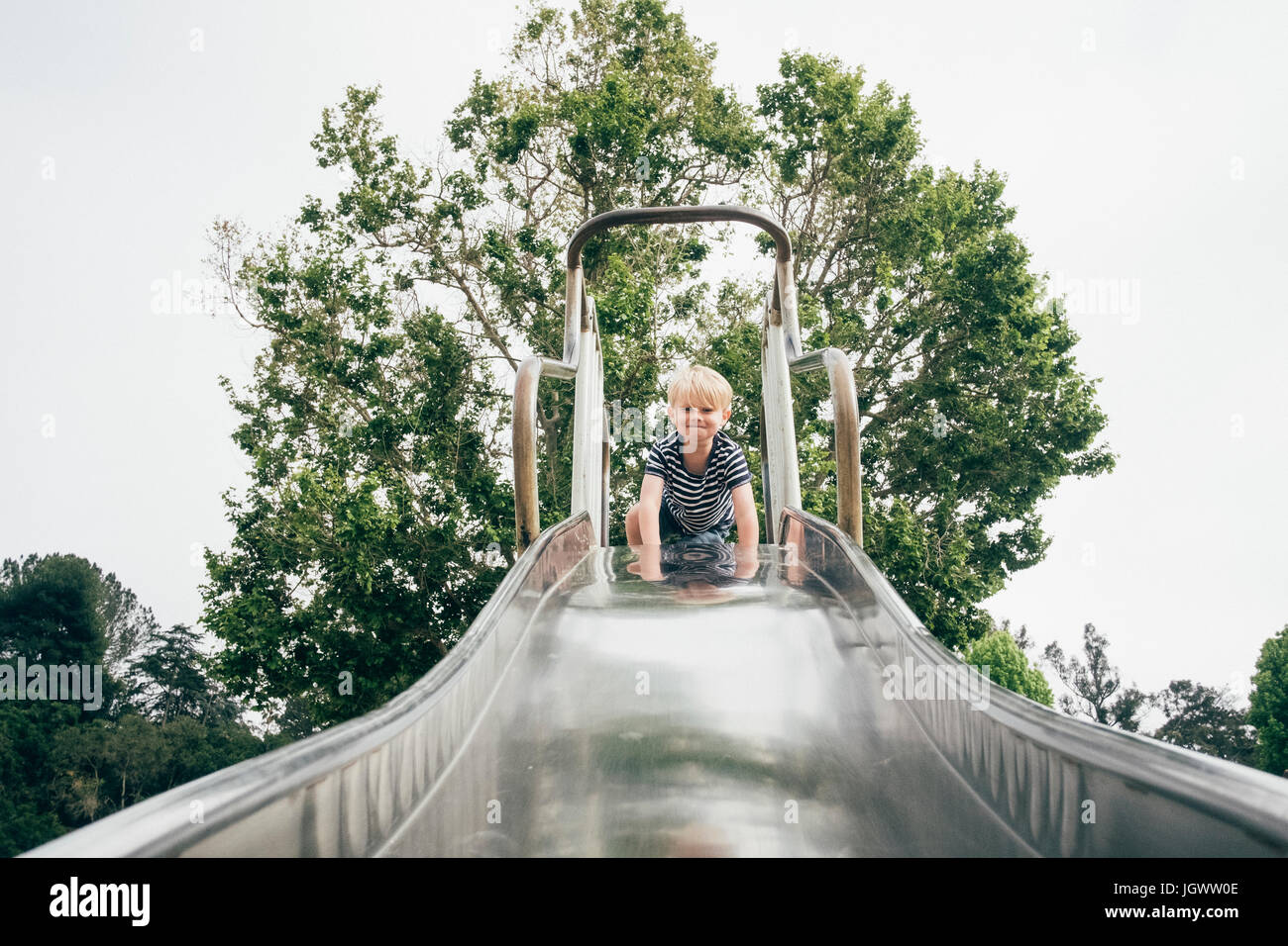 Portrait of boy at top of playground slide, low angle view Stock Photo Alamy