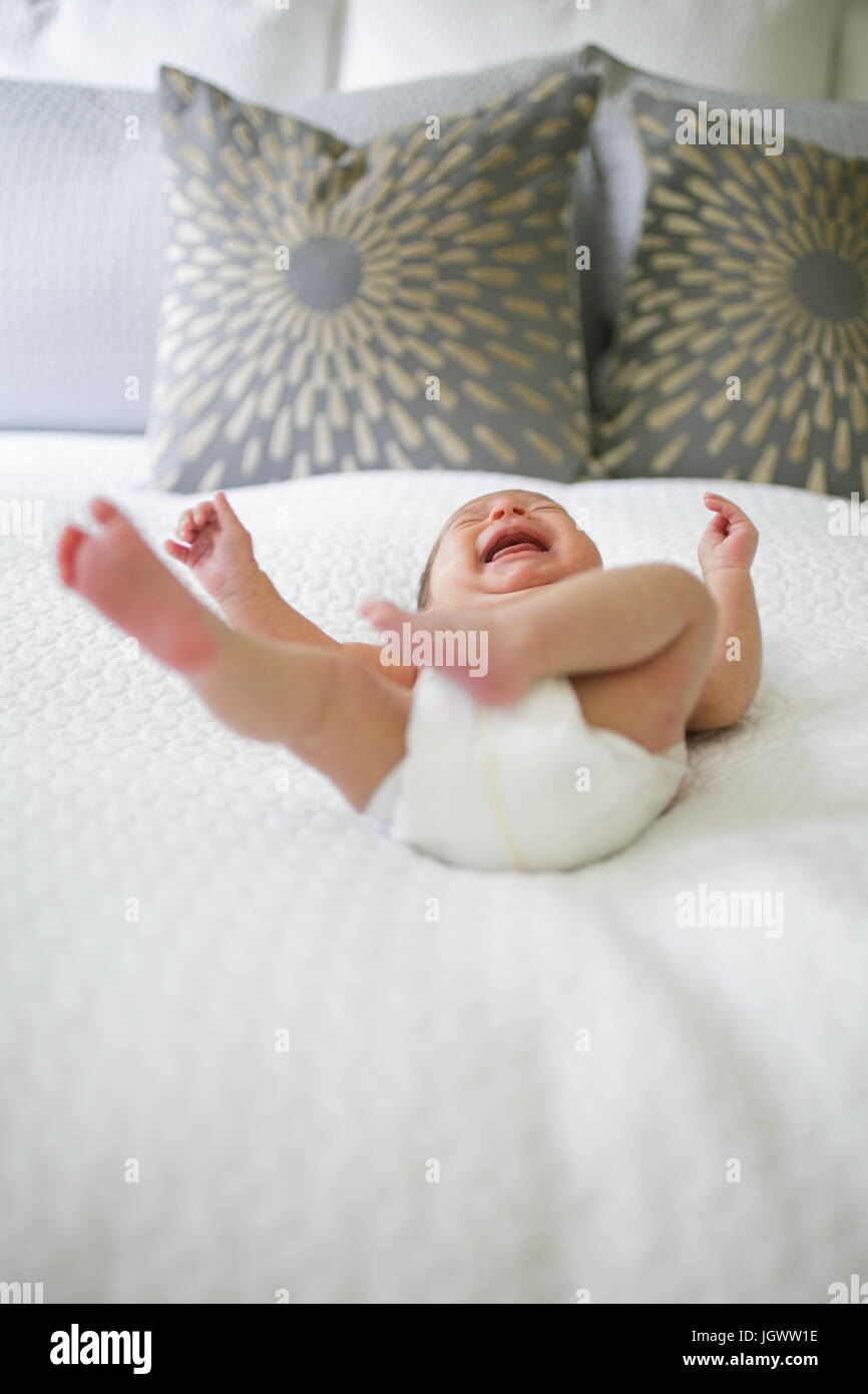 Baby boy, lying on bed, crying, low angle view Stock Photo