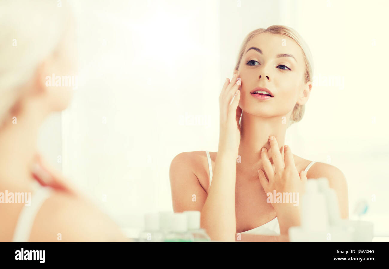 happy young woman looking to mirror at bathroom Stock Photo - Alamy