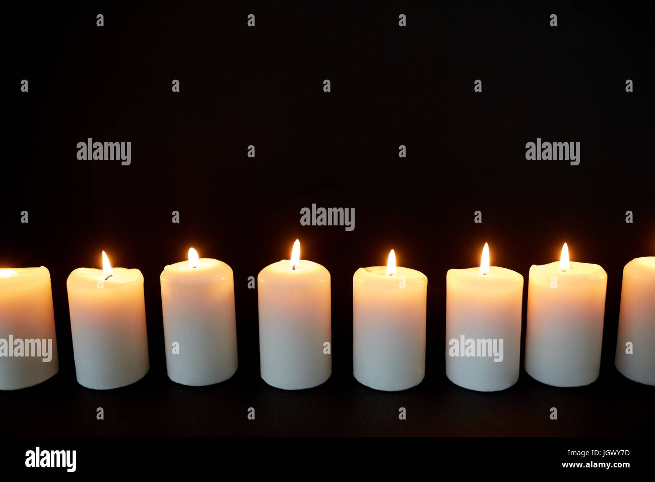candles burning in darkness over black background Stock Photo Alamy
