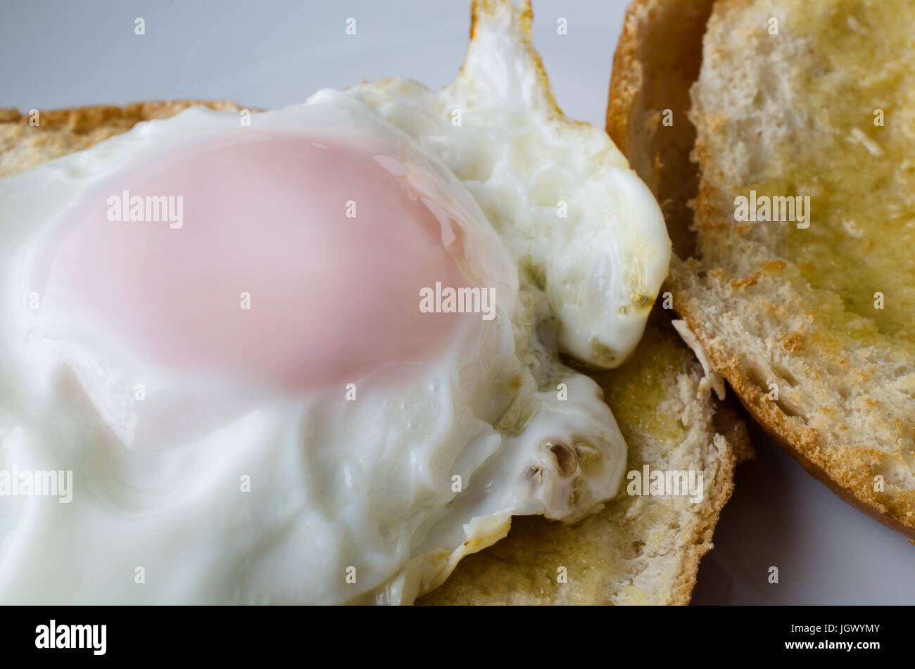 Close up shot of  free range fried egg on a toasted, sliced bagel. Still whole and ready to eat. Stock Photo