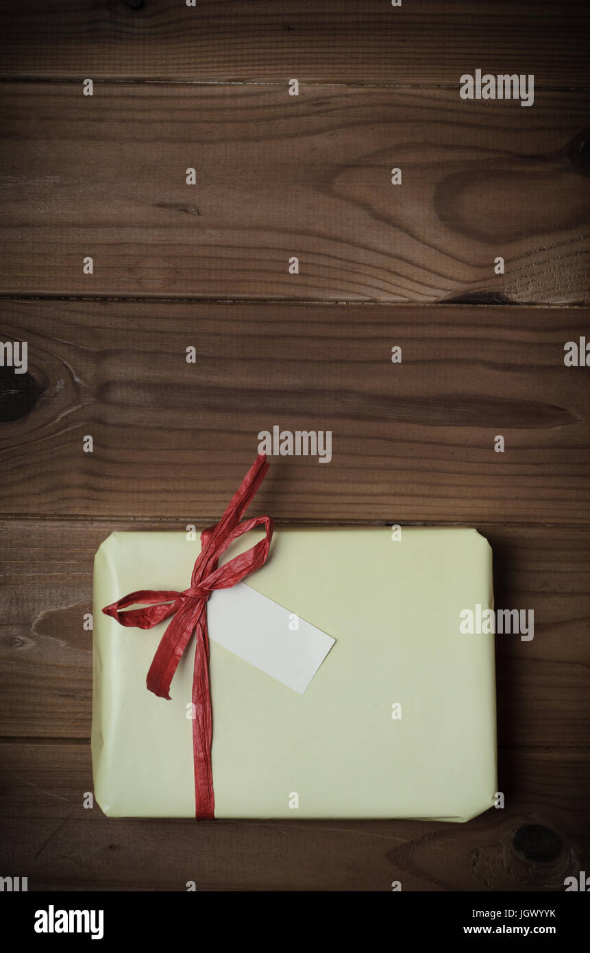 Gift box wrapped in gold wrapping paper, decorated with red raffia ribbon  and bow isolated on the white background Stock Photo - Alamy