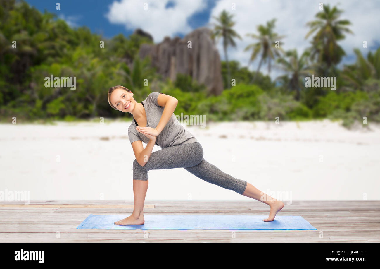 woman doing yoga side angle pose on beach Stock Photo