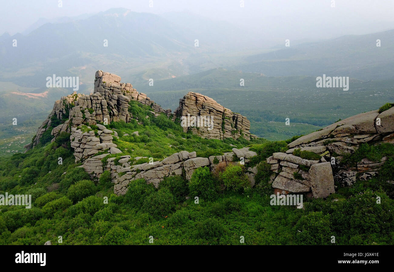 Shijiazhuang. 10th July, 2017. Photo taken on July 10, 2017 shows the scenery of the stone field on the top of Bingshanliang Mountain in Chicheng County, north China's Hebei Province. On the top of Bingshanliang Mountain at an altitude of more than 2,000 meters, there are an array of peaks and rocks of all forms as the rare Mesozoic glacial remnants. The mountain mainly consists of granite, limestone and basalt. Credit: Yang Shiyao/Xinhua/Alamy Live News Stock Photo
