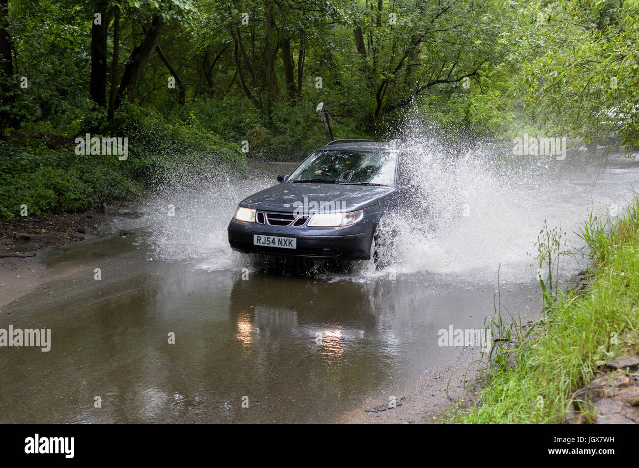 Oxton, Nottinghamshire, UK:11th July 2017: A water ford on the River Dove Beck near the village of Oxton begins to overflow after continuous torrential rain, drivers take care passing through. Credit: Ian Francis/Alamy Live News Stock Photo