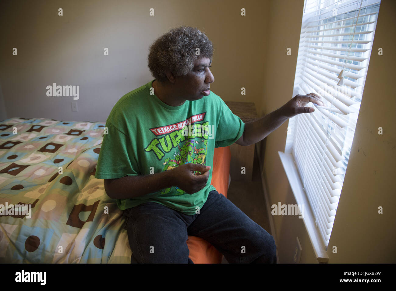 Athens, GA, USA. 13th Oct, 2014. Perry Hendricks gazes out window from his private bedroom at his duplex apartment. He is supported by staff from the Georgia Options non-profit organization that helps individuals with developmental disabilities live independently, with funding from their Medicaid waivers. Perry lived in state institutions for decades before transitioning to his own home. Credit: Robin Rayne Nelson/ZUMA Wire/Alamy Live News Stock Photo