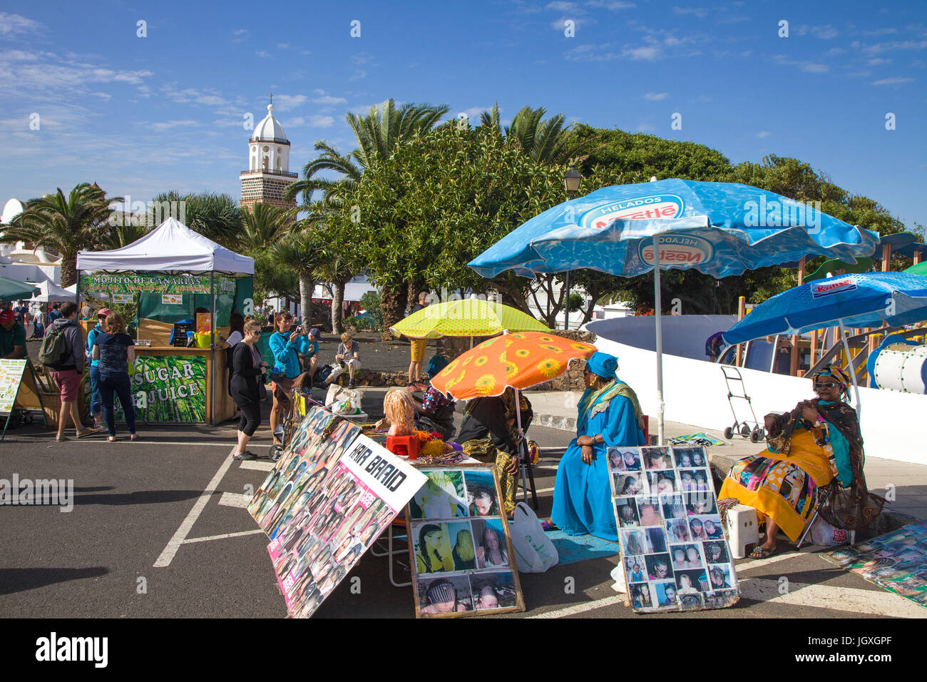Afrikanische Frauen an einem Rastalocken-Stand auf dem woechentlicher Sonntagsmarkt in Teguise, Lanzarote, Kanarische Inseln, Europa | African women a Stock Photo