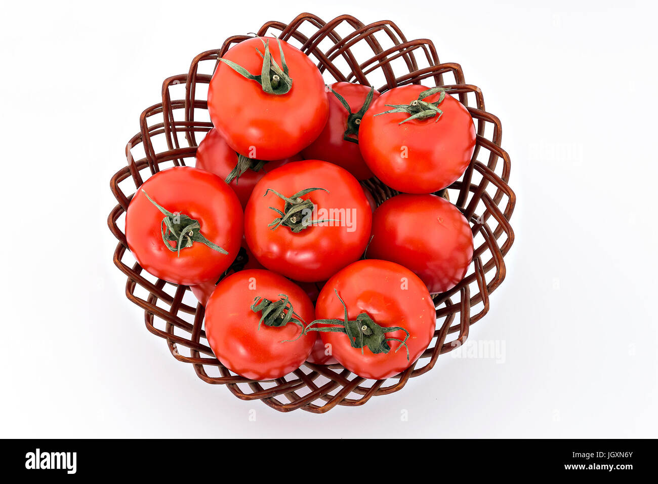 Tomatoes in woven basket on white background, top view Stock Photo - Alamy