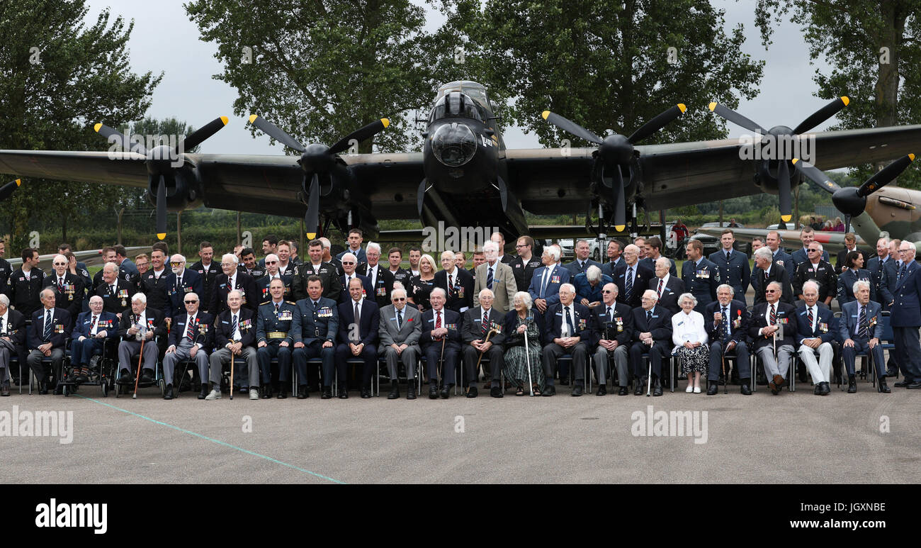 The Duke of Cambridge poses for a group photograph with veterans after a reception marking the Battle of Britain Memorial Flight's 60th anniversary during his visit to RAF Coningsby in Lincolnshire. Stock Photo
