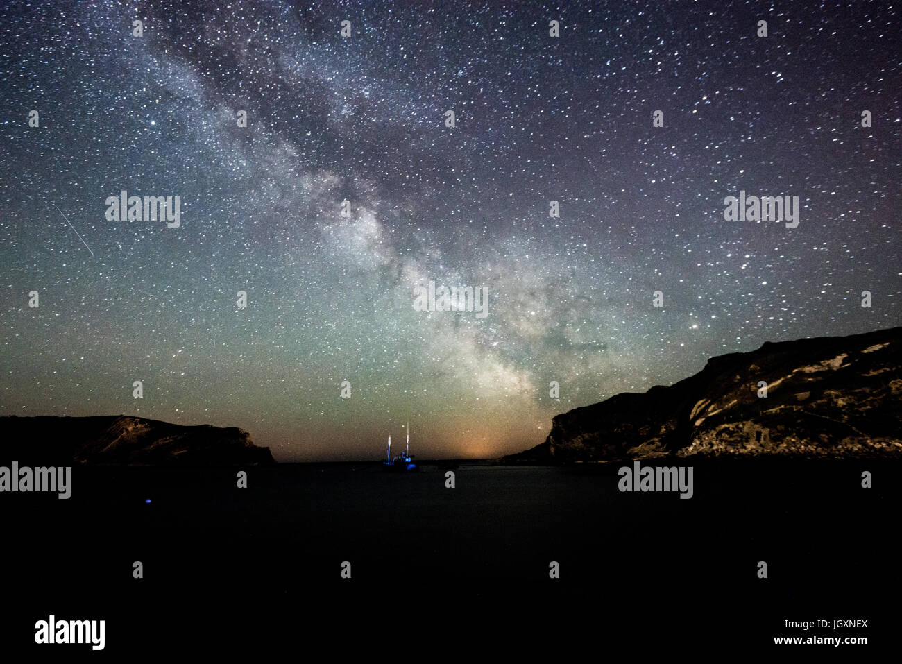 Clear skies above Lulworth Cove reveal the Milky Way and millions of stars, Dorset, England, UK Stock Photo