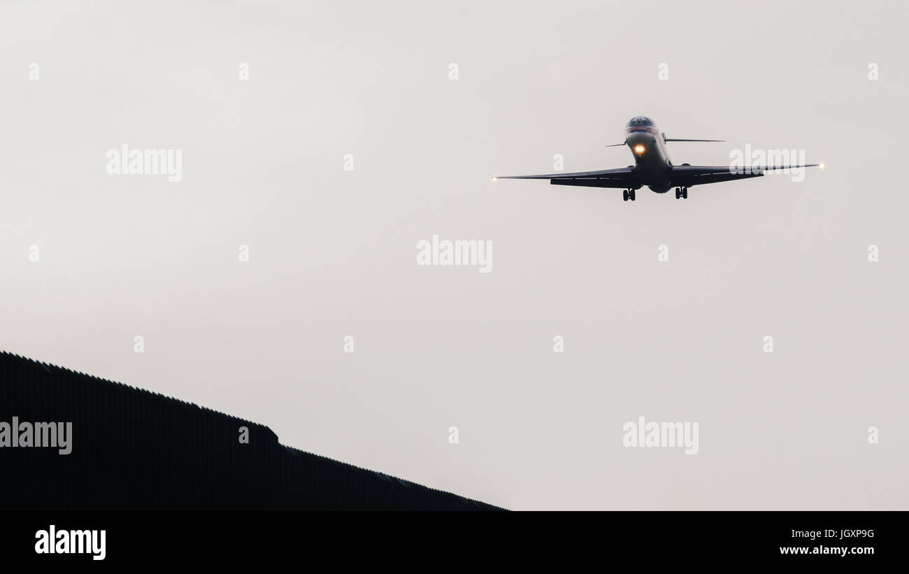 Airplane approaching runway to land at airport Stock Photo