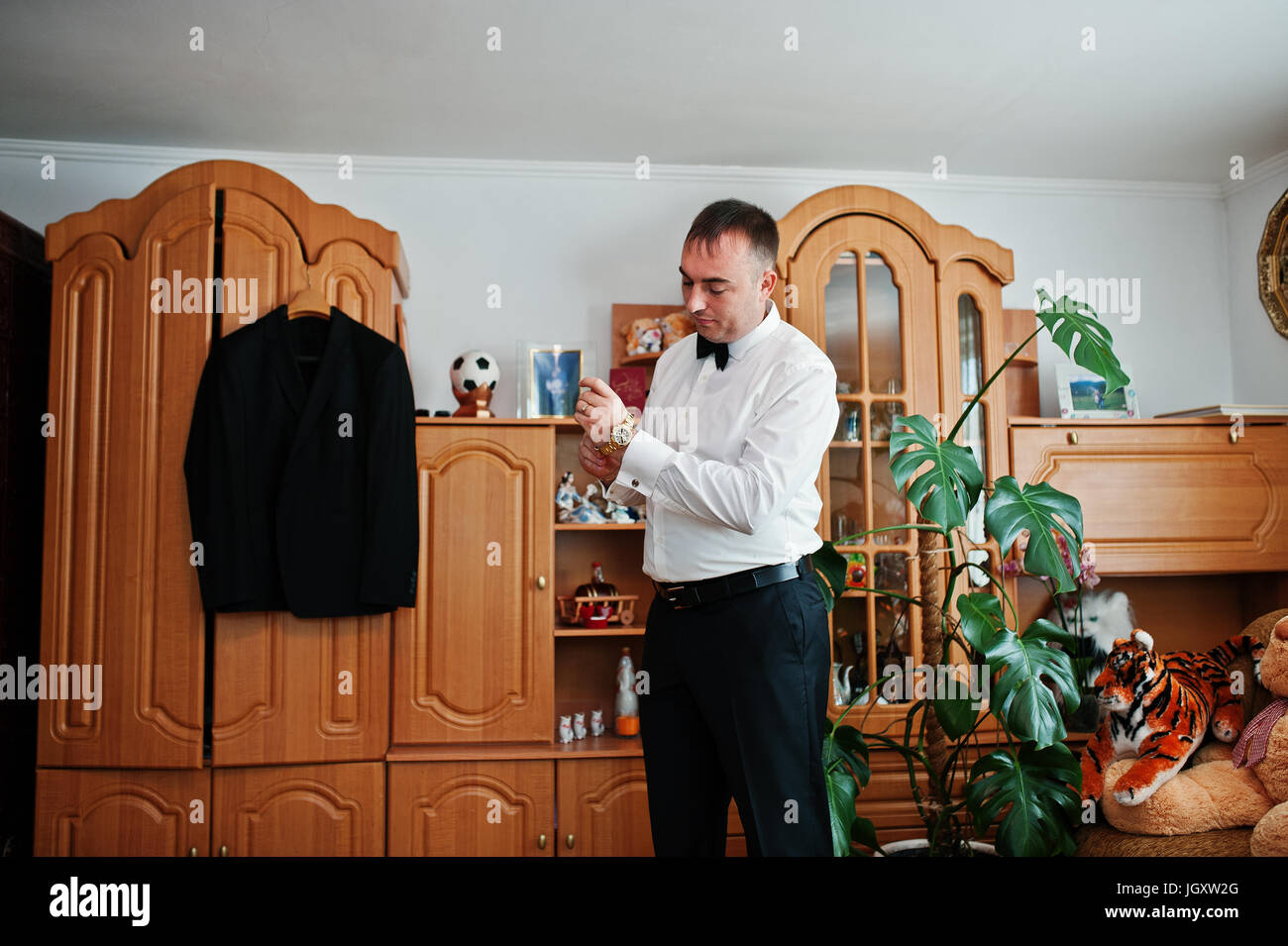Handsome groom dressing up in his room for his wedding ceremony Stock
