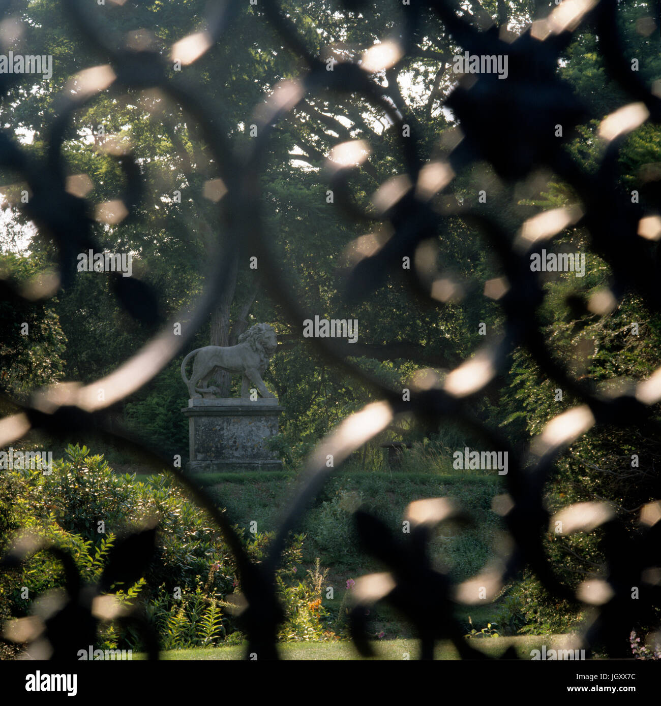 Lion statue through metal fence Stock Photo