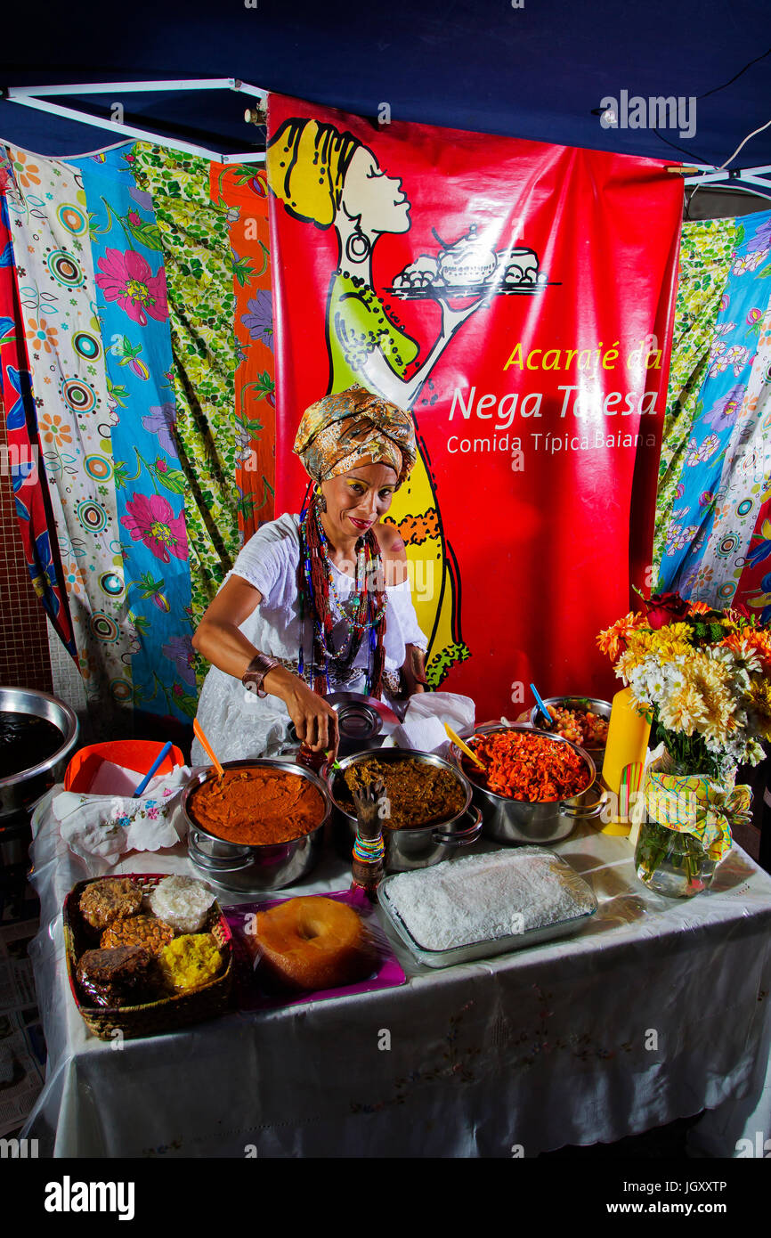Baiana in traditional clothes preparing acarajé, a tipycal food from