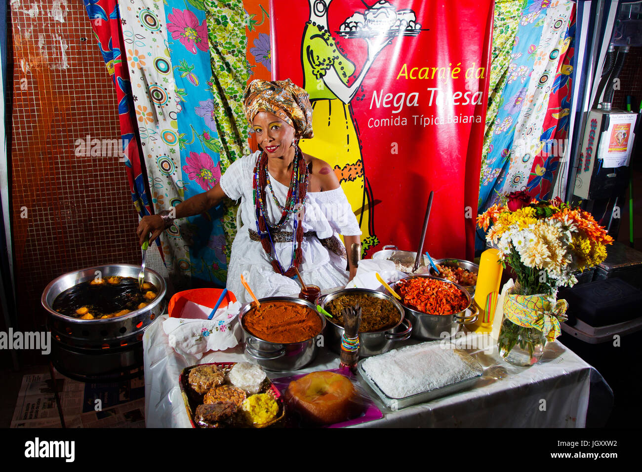 Baiana in traditional clothes preparing acarajé, a tipycal food from