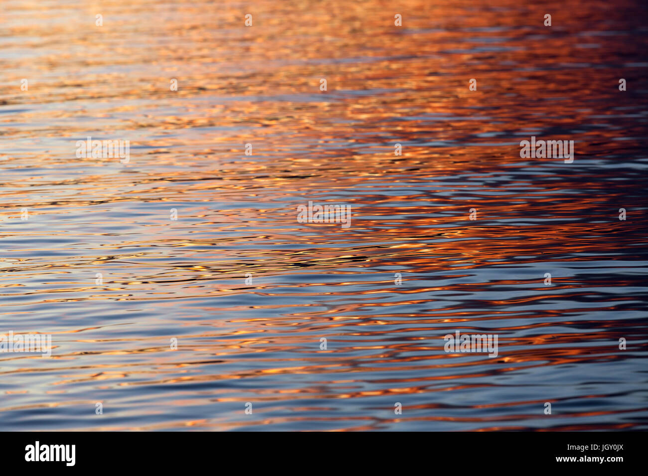 Beautiful red and orange sunset reflections on a calm bay of water. Stock Photo