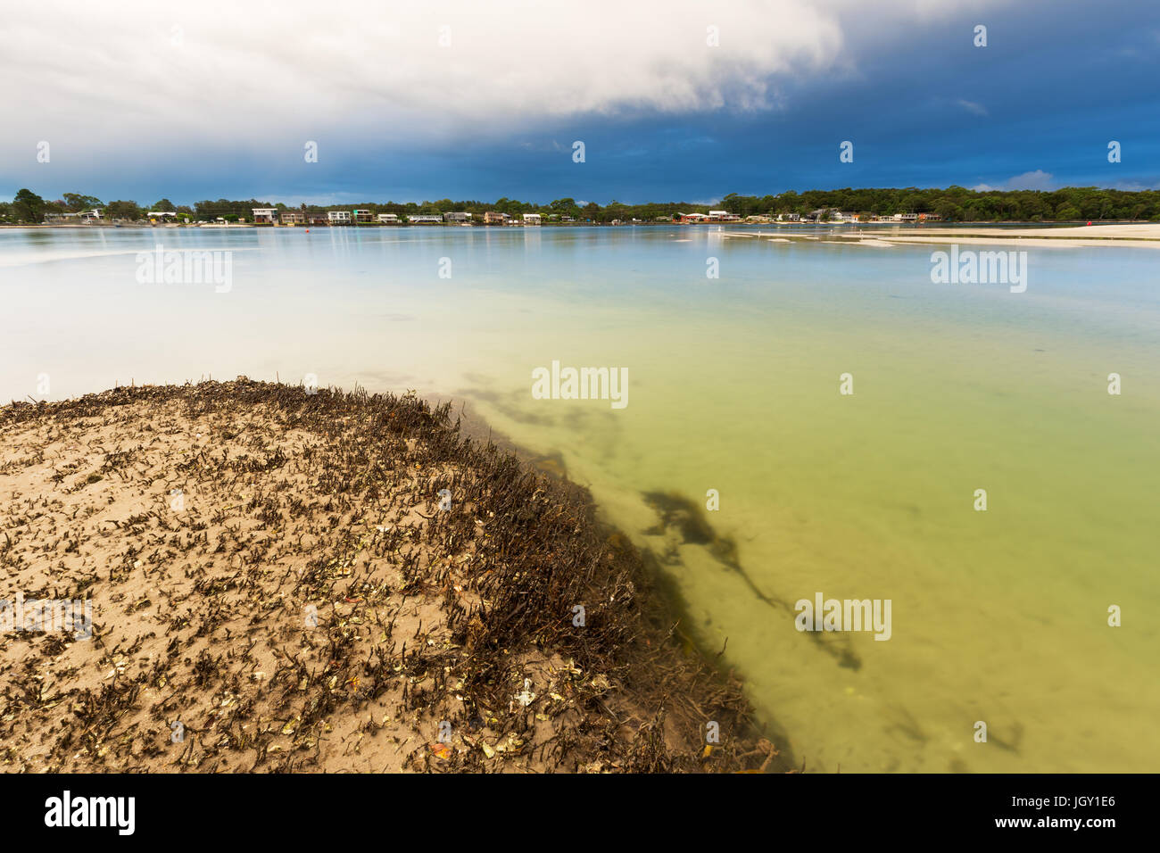 A storm passes over a tranquil river and mangrove system in eastern Australia. Stock Photo